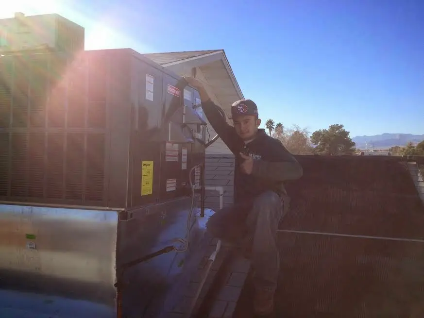 HVAC technician performing HVAC Inspection on a rooftop unit in Corry